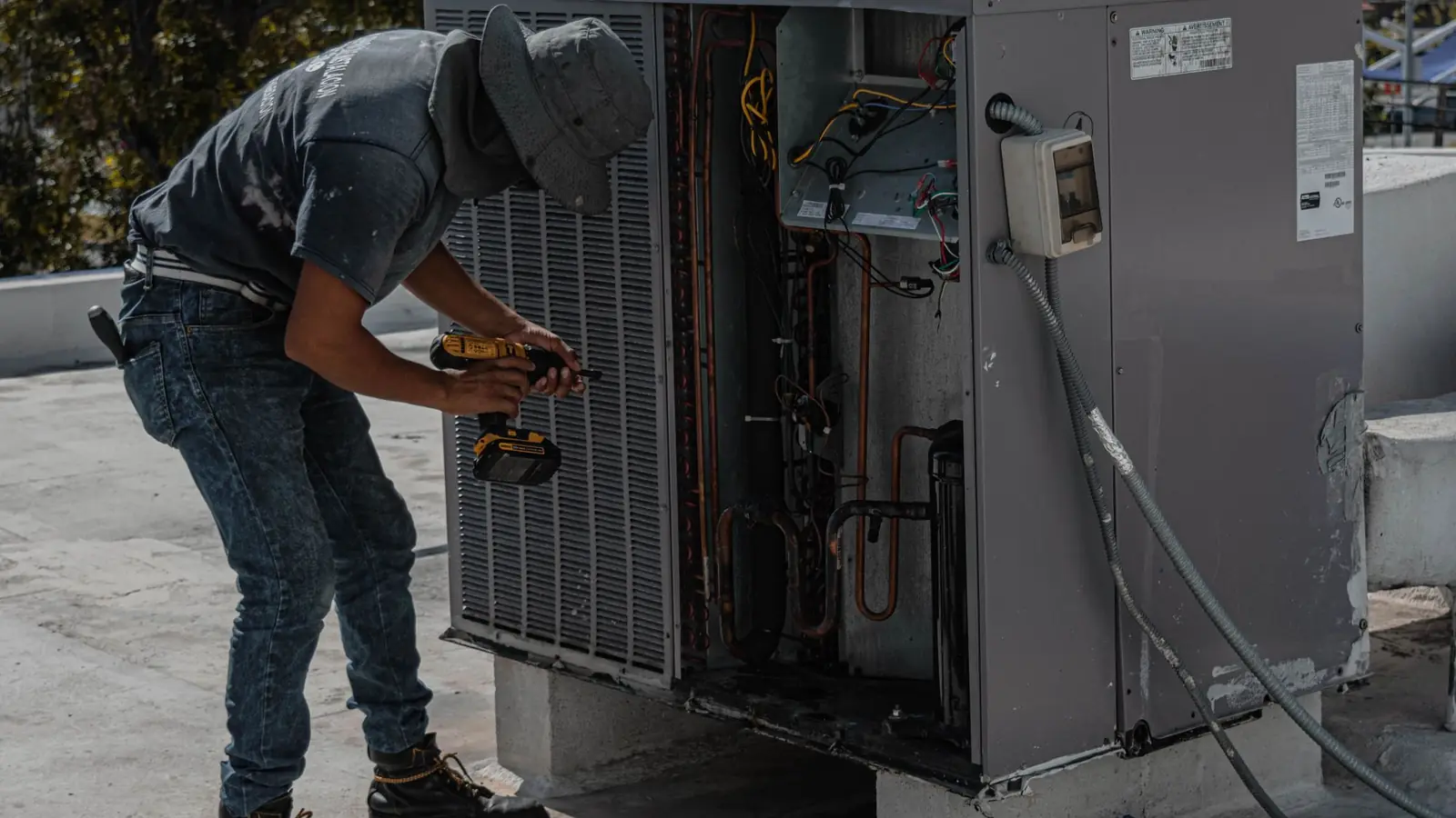 HVAC technician servicing a rooftop air-conditioning unit