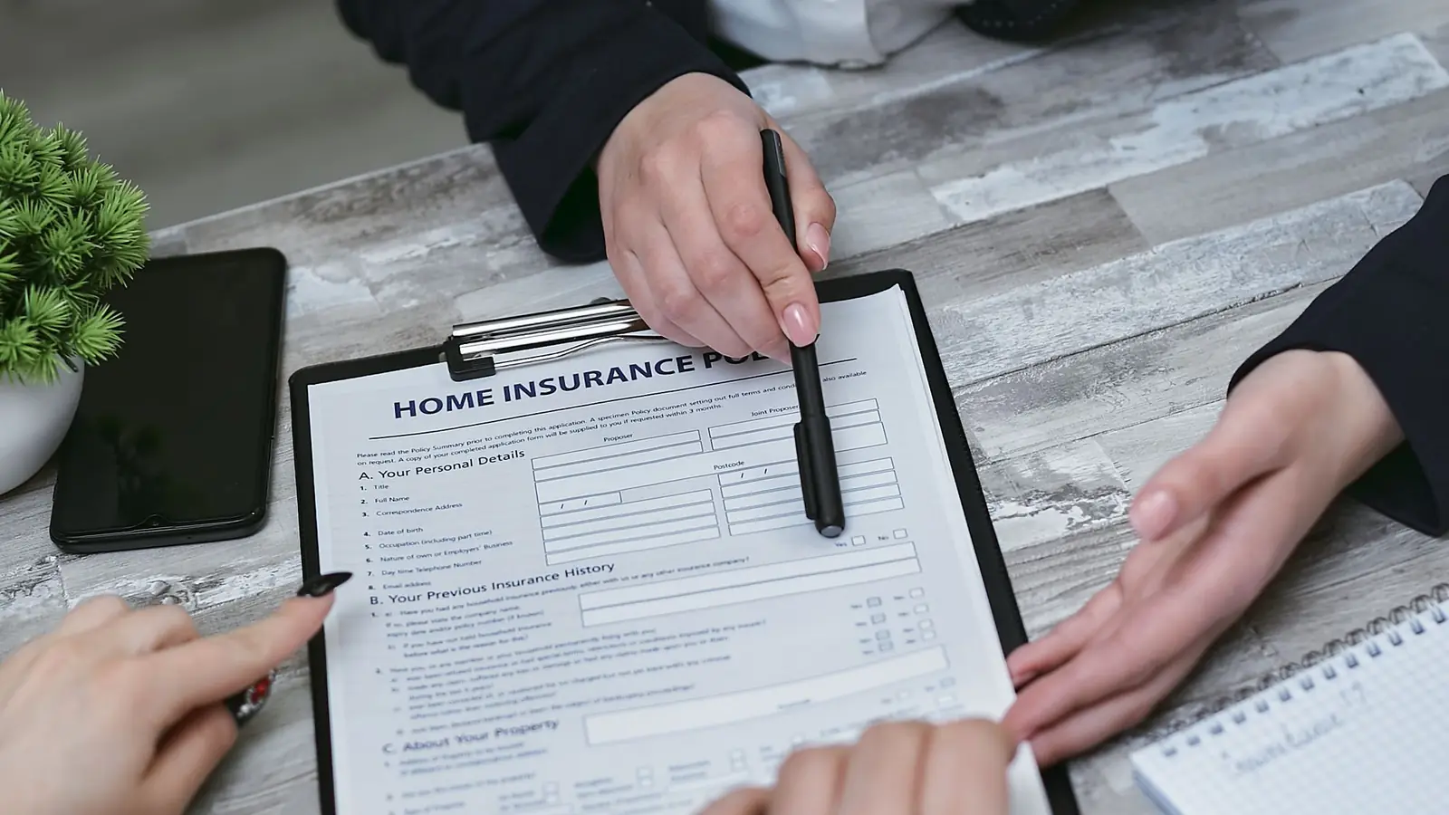 Insurance agent reviewing a home insurance form with clients