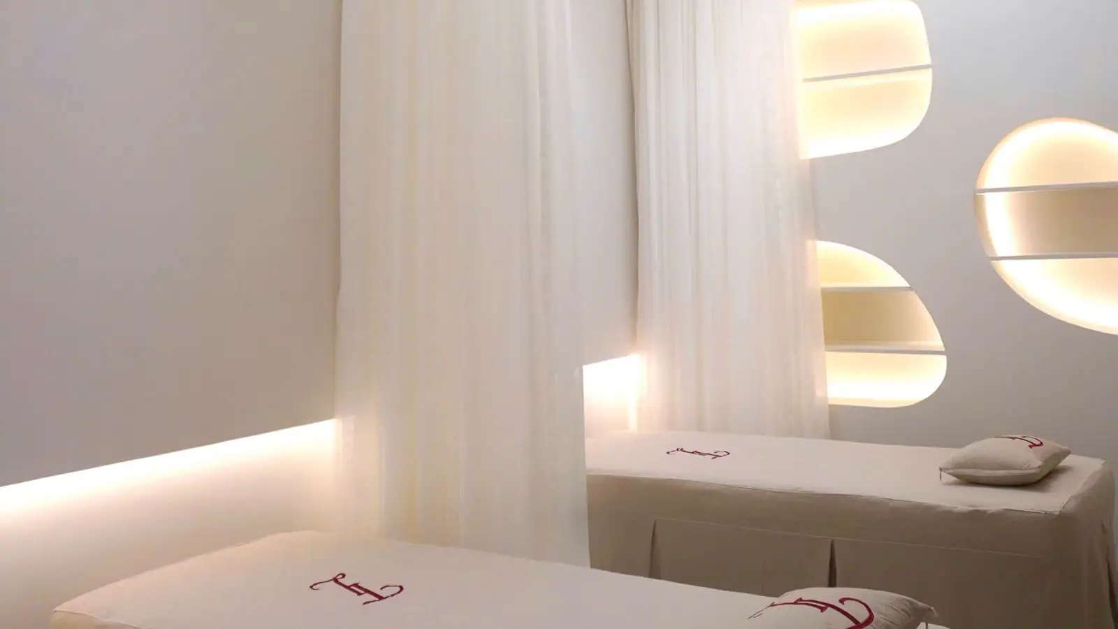 Softly lit med spa treatment room with treatment beds